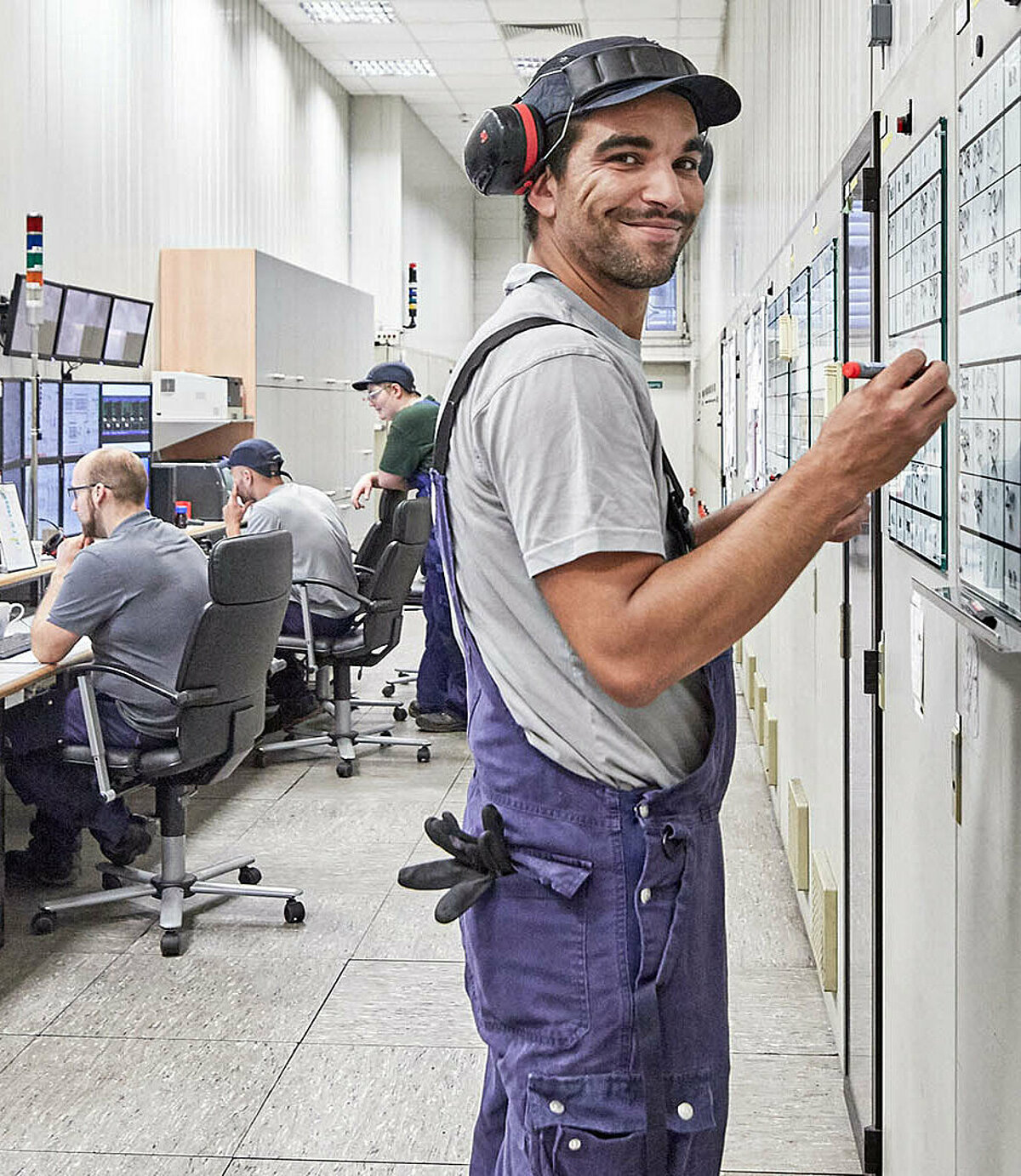 Mitarbeiter arbeitet in seinem Job bei CR3 in Bremen-Industriehäfen, Gröpelingen vor einem Whiteboard mit Blaumann und Handwerk