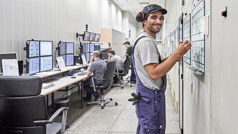 Mitarbeiter arbeitet in seinem Job bei CR3 in Bremen-Industriehäfen, Gröpelingen vor einem Whiteboard mit Blaumann und Handwerk
